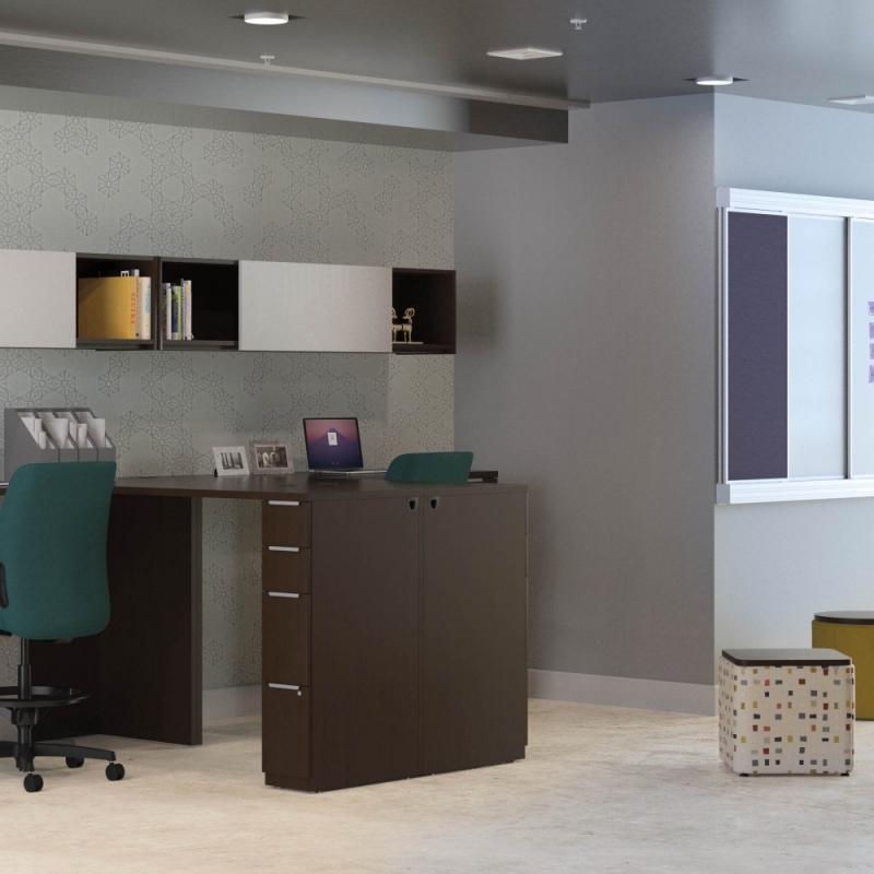 large office space with several desks at bar stool height and with a small seating area next to the desks.