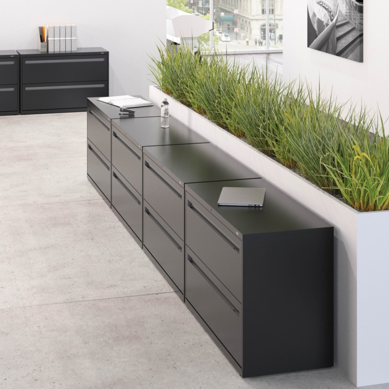 gray 2 by 4 drawer filing cabinet with a column of plants behind it